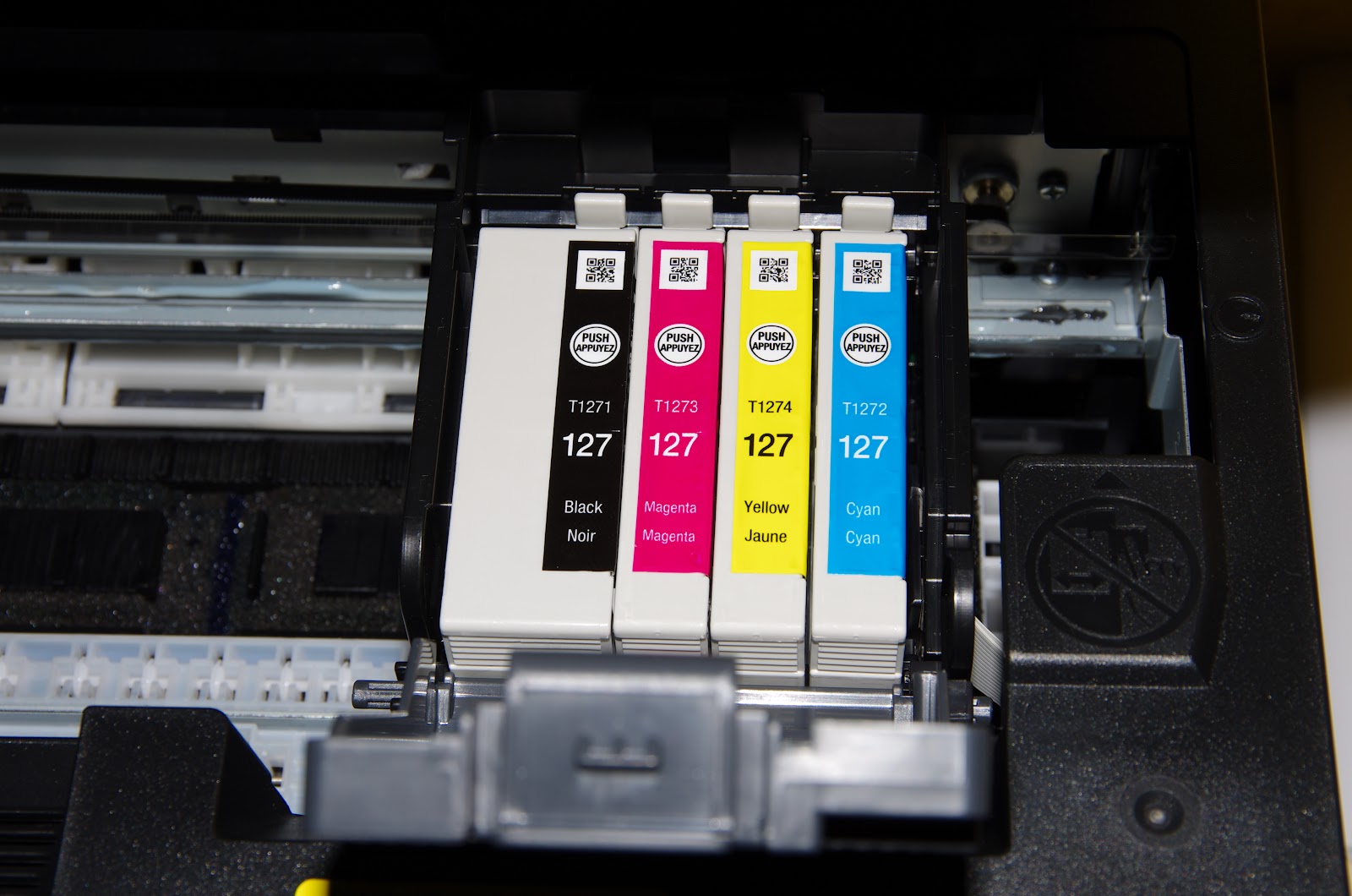 Quatre cartouches d'encre (noir, magenta, jaune et cyan) dans une imprimante Epson