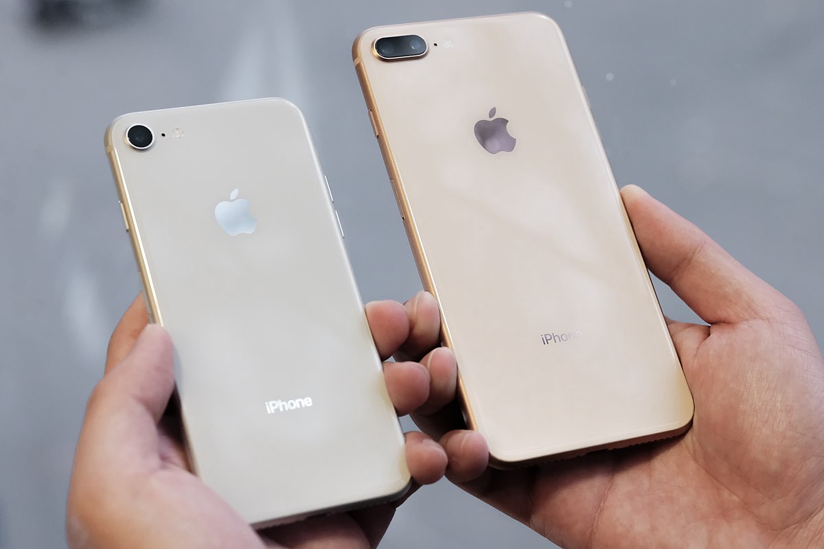 Deux mains tenant l'iPhone 8 et l'iPhone 8 plus, qui est de plus grande taille, pour voir la comparaison entre les deux