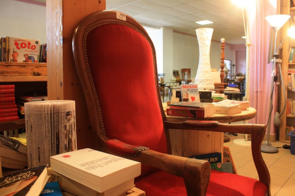 Image de la ressourcerie de Rillieux-la-Pape.  Il y a du mobilier, une table en palette recyclé, des livres, des lampes...