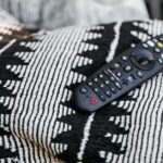 Télécommande de télévision posée près d’un écran, pour illustrer un dépannage TV High One