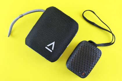 Deux enceintes portables noires sur fond jaune — illustration pour un guide de charge