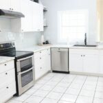 A bright and spacious modern kitchen with white cabinets, appliances, and natural light.
