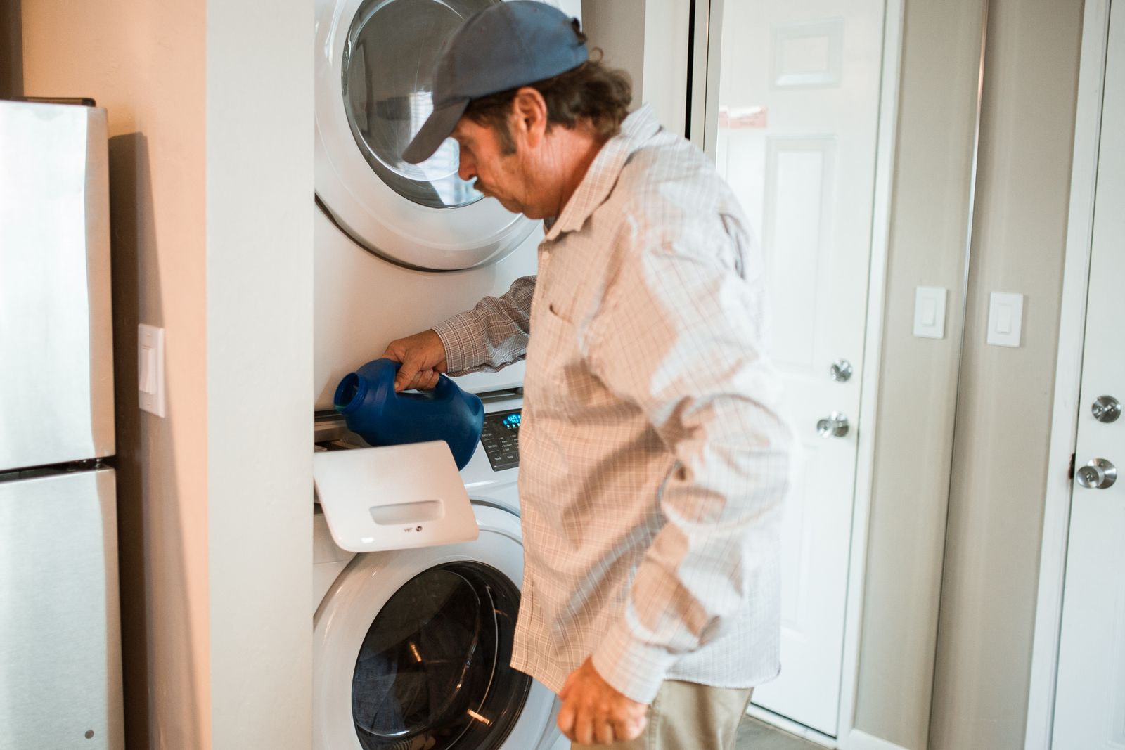 Lessive versée dans un lave-linge, illustration pour un guide de dépannage